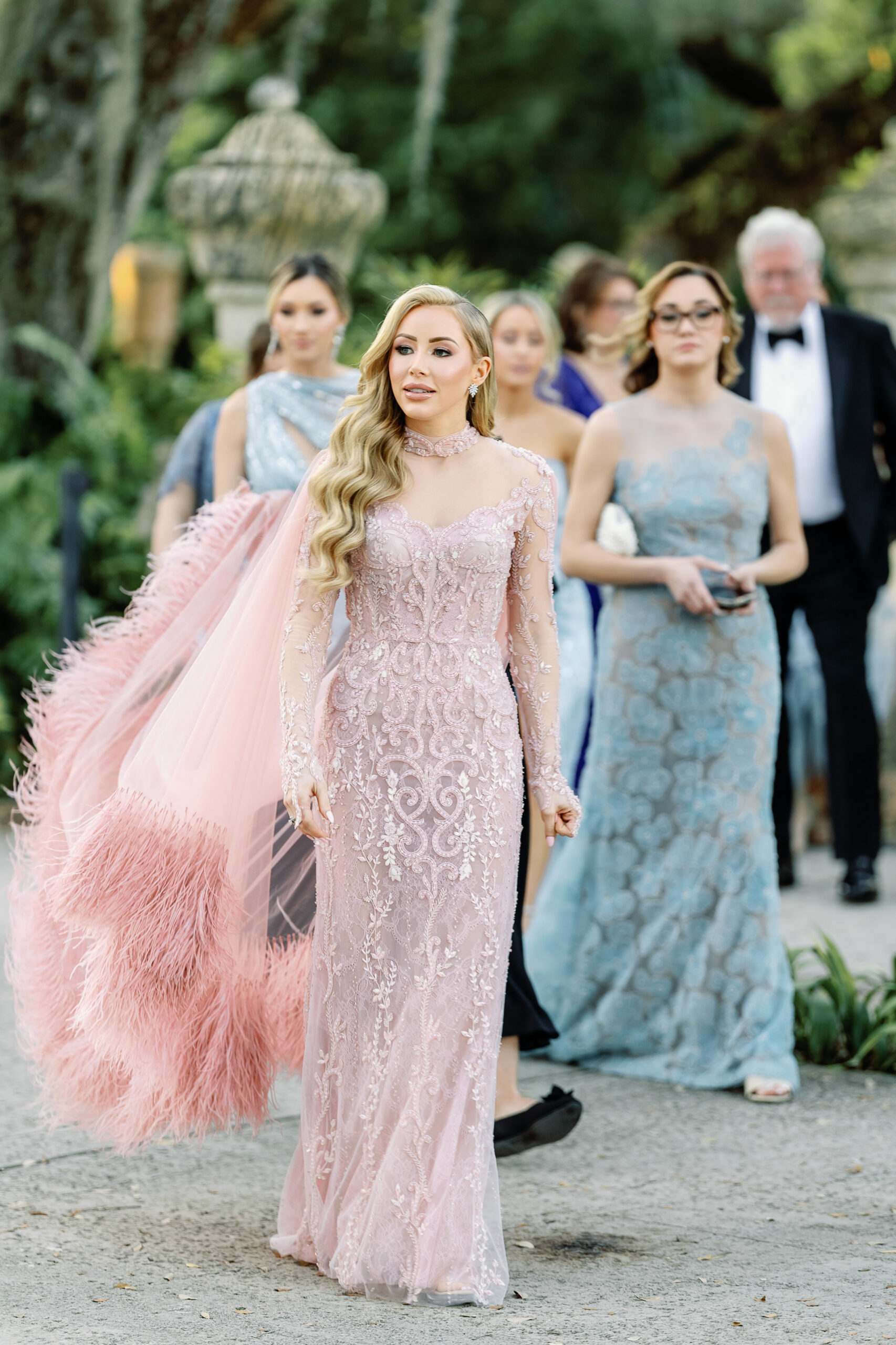 Bailey arriving in blush feathered gown at Vizcaya