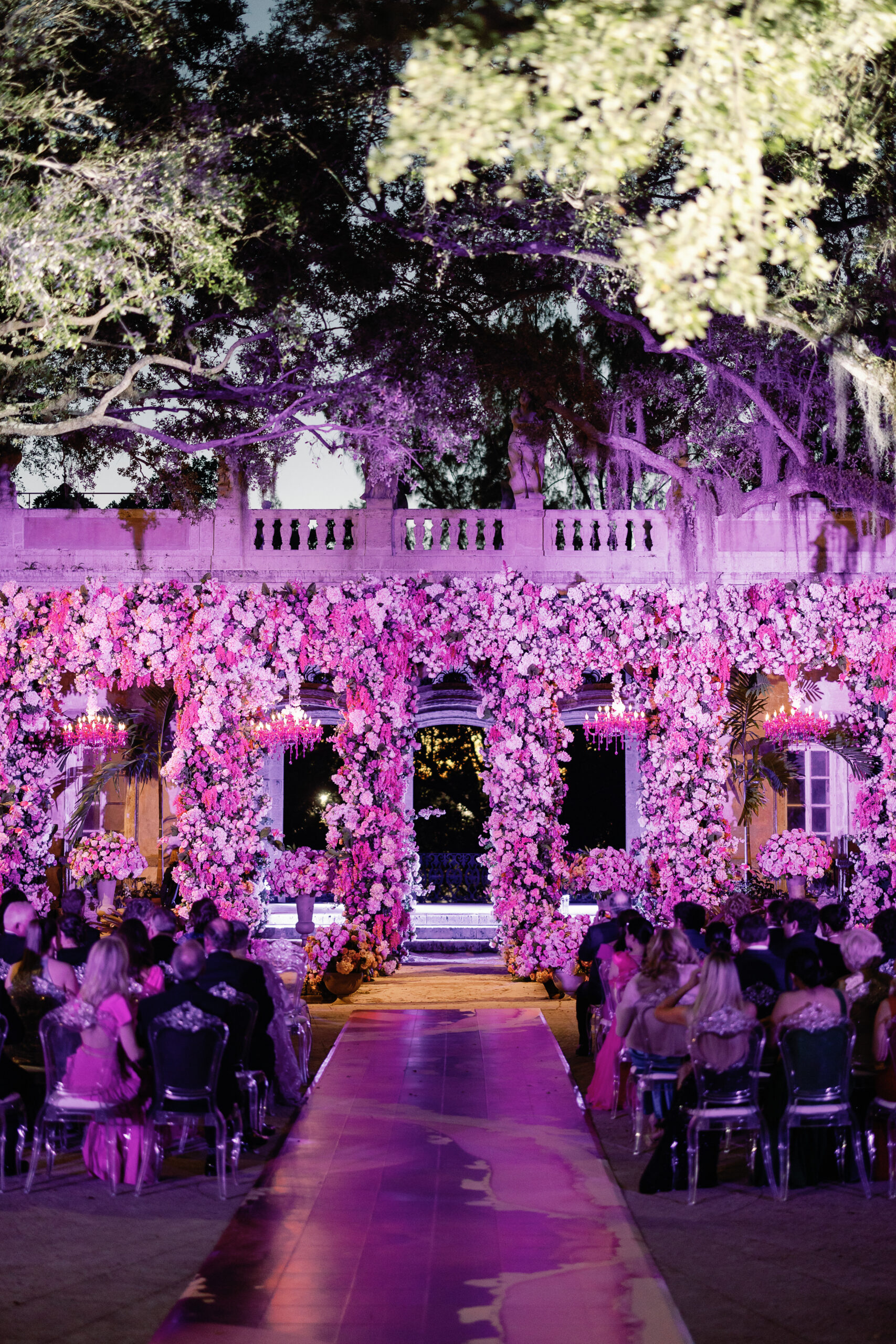 Ceremony at night - lit by purple wash and chandeliers at Vizcaya